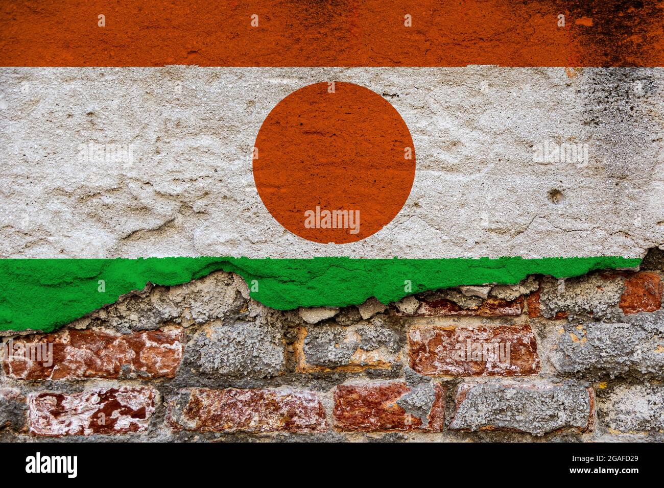 Grafisches Konzept mit einer Flagge von Niger auf einer beschädigten Ziegelwand. Stockfoto