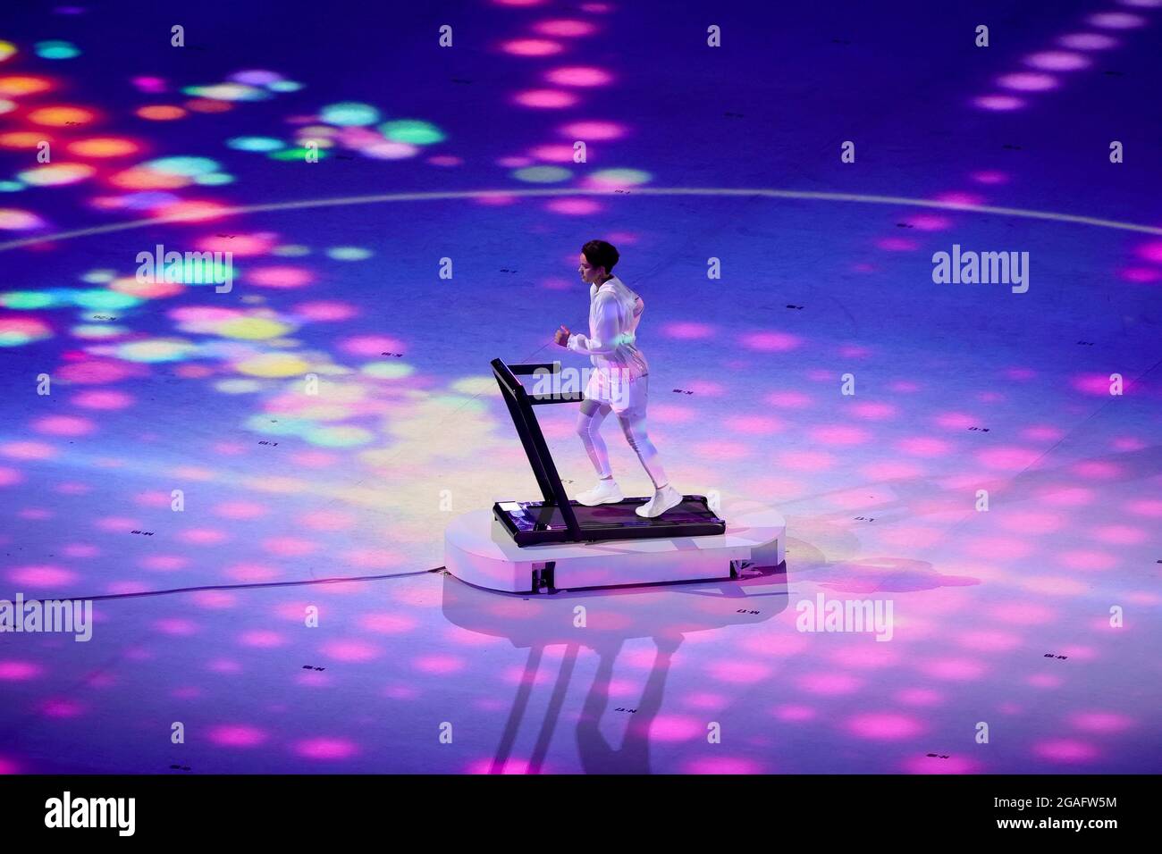 Tokio, Japan, 23. Juli 2021. Ein Performer, der während der Eröffnungszeremonie der Olympischen Spiele 2020 in Tokio im Olympiastadion auf einem Laufband läuft. Quelle: Pete Dovgan/Speed Media/Alamy Live News Stockfoto