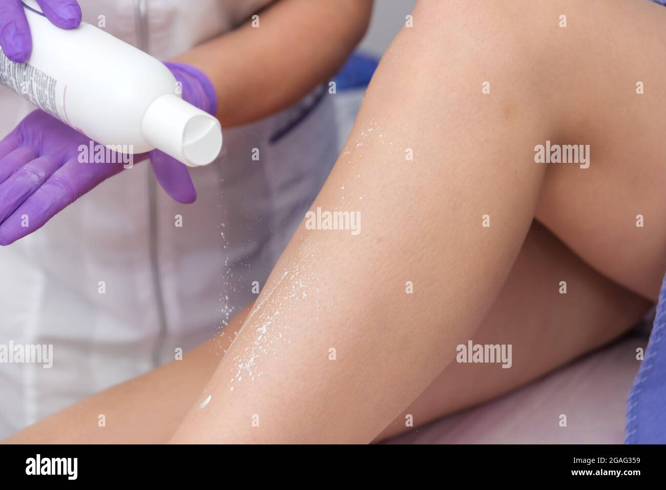 Kosmetisches Verfahren Anwendung von Talkum auf die Beine Enthaarung Epilation Reiben Talkum Haut Erweichung Stockfoto