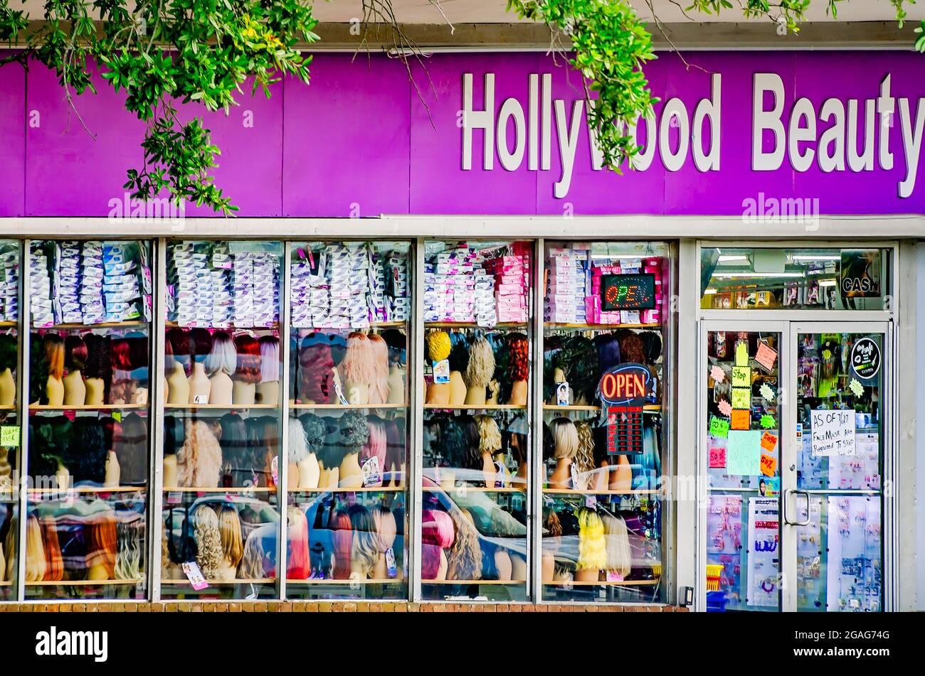 Perücken und andere persönliche Gegenstände werden im Fenster von Hollywood Beauty Supply, 28. Juli 2021, in Mobile, Alabama, ausgestellt. Stockfoto