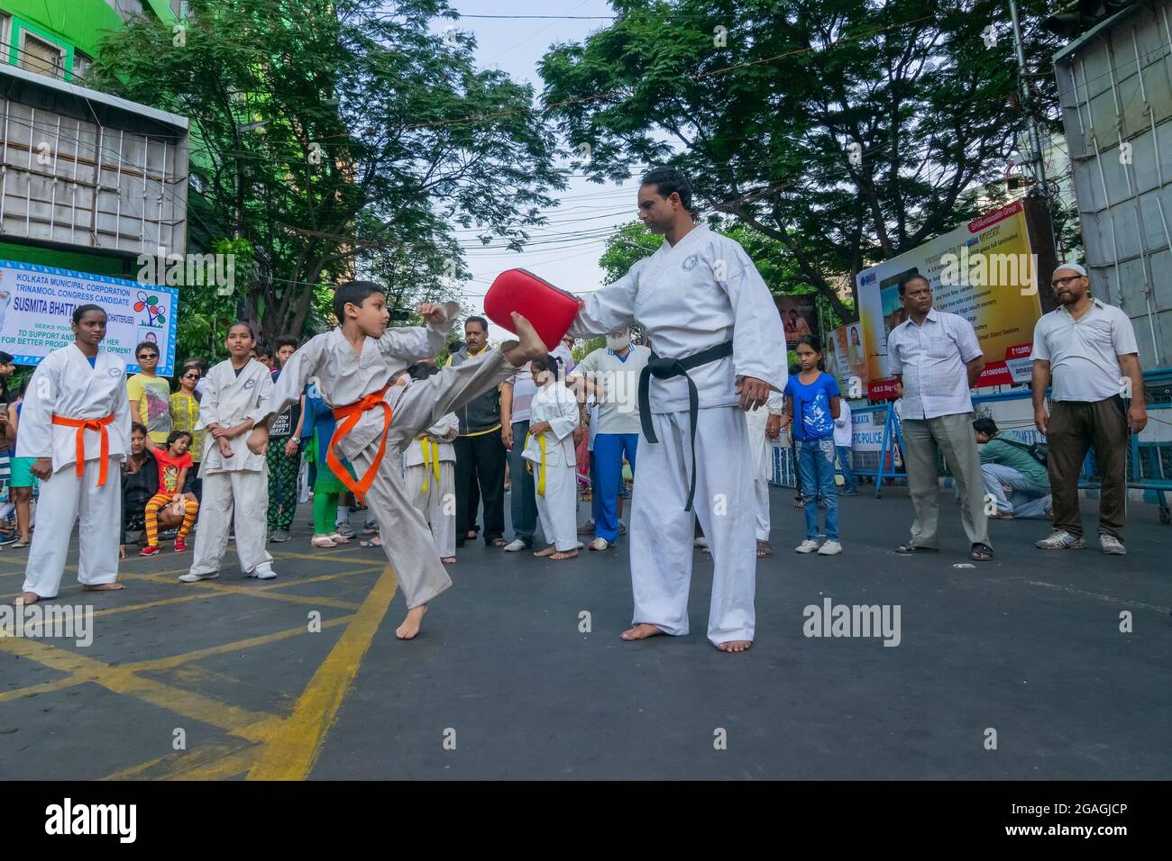 KALKUTTA, WESTBENGALEN, INDIEN - 29. MÄRZ 2015 : weiß gekleideter Junge springt zum Kick, praticing Karate - 'Happy Street' Veranstaltung auf der Park Street, Kalkutta. Ch Stockfoto