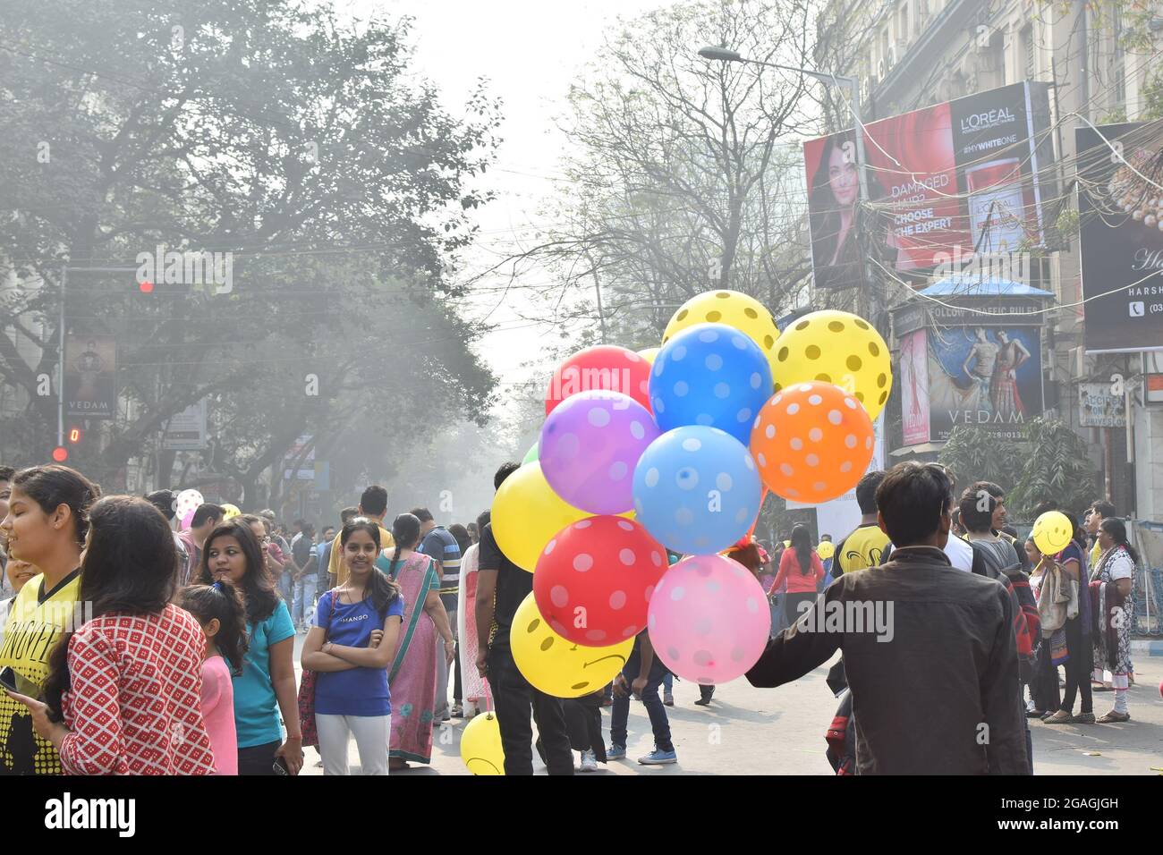 KALKUTTA, WESTBENGALEN, INDIEN - 7. FEBRUAR 2016 : nicht identifizierter Mann, der Ballone an Stadtkinder auf der blockierten, ansonsten geschäftigen Park Street für 'Happ Stockfoto