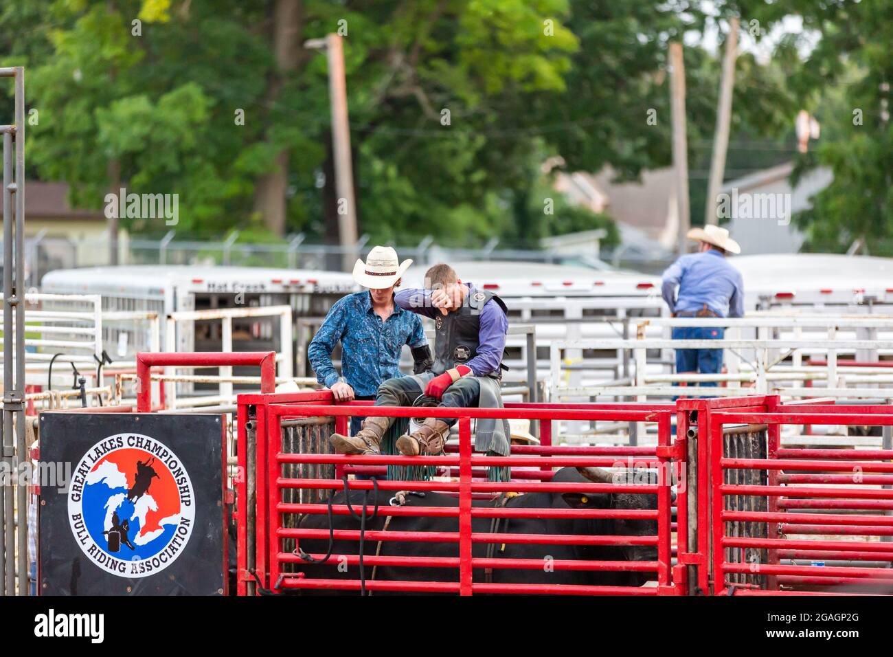 Ein Cowboy wischt sich die Stirn, nachdem er während einer Stierritt-Veranstaltung auf dem Noble County Fairgrounds in Kendallville, Indiana, USA, von einem Stier geworfen wurde. Stockfoto