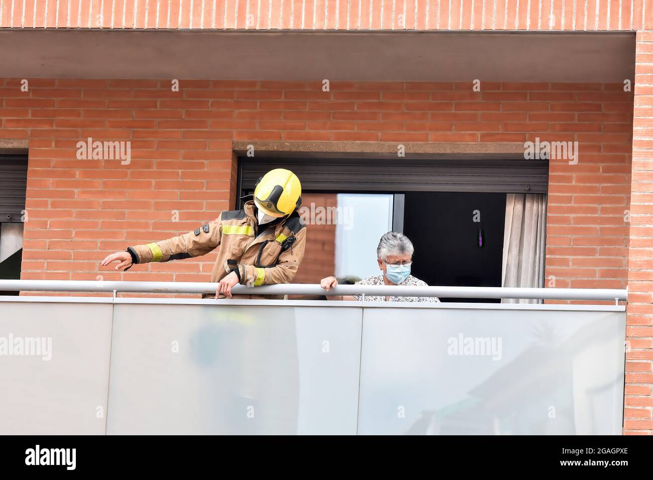 Ein Feuerwehrmann aus Katalonien, der mit einem Mieter auf der Terrasse eines Hauses bei einer Inspektion auf ein mögliches Gasleck in Vendrell gesehen wurde. Ein starker Gasgeruch alarmierte die Bewohner der San Jordi Street in Vendrell, wo drei Teams von Catalonia Firefighters und mehrere örtliche Polizeipatrouillen den Zugang zum betroffenen Gebiet verschließten. Feuerwehrleute begannen mit Hilfe von Technikern des Gasunternehmens mit den Gasmessungen, da der Geruch aus dem unterirdischen Kanalnetz kam und das Vorhandensein von Dämpfen oder Konzentrationen von Propan, Butan oder Erdgas ausgeschlossen wurde, so dass ein Gasleck ausgeschlossen wurde und das p Stockfoto