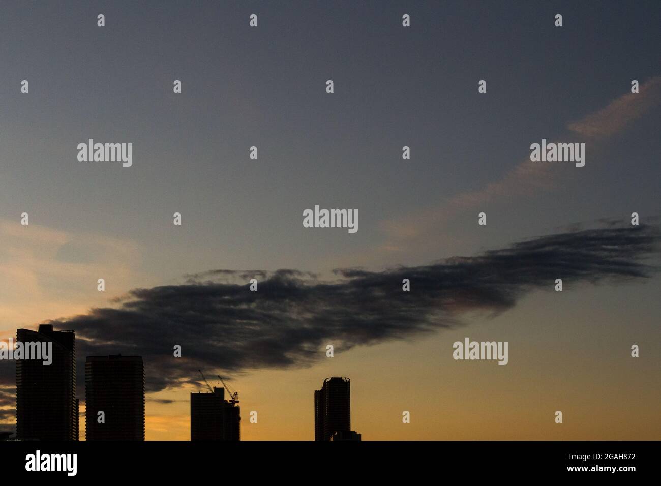 In der Abenddämmerung in Musashi Kosugi, Kanagawa, Japan, hängt eine große Wolke über den Silhouetten von Wolkenkratzern. Stockfoto