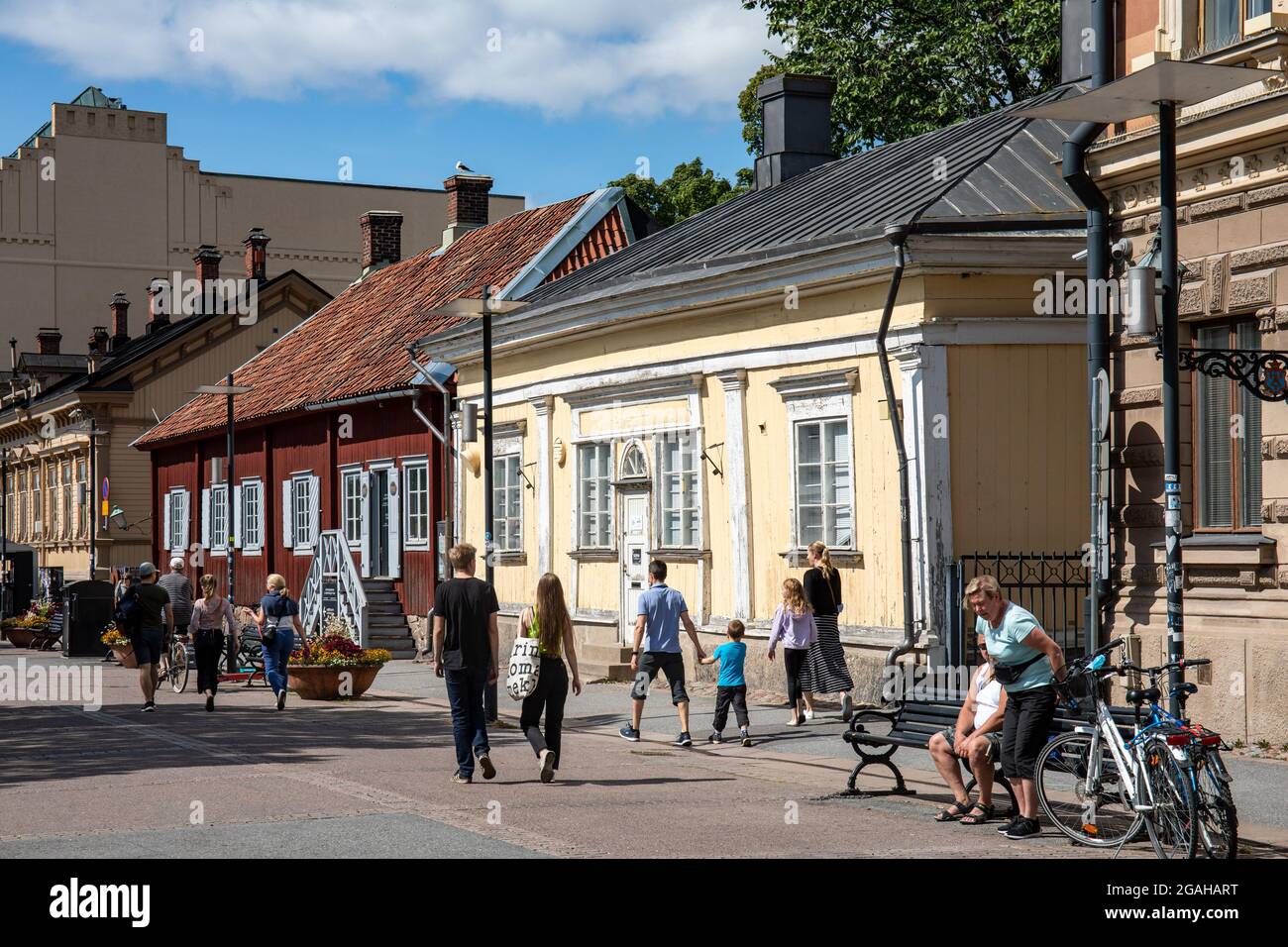 Menschen, die an Länginen Rantakatu alten Holzhäusern in Turku, Finnland, vorbeigehen Stockfoto