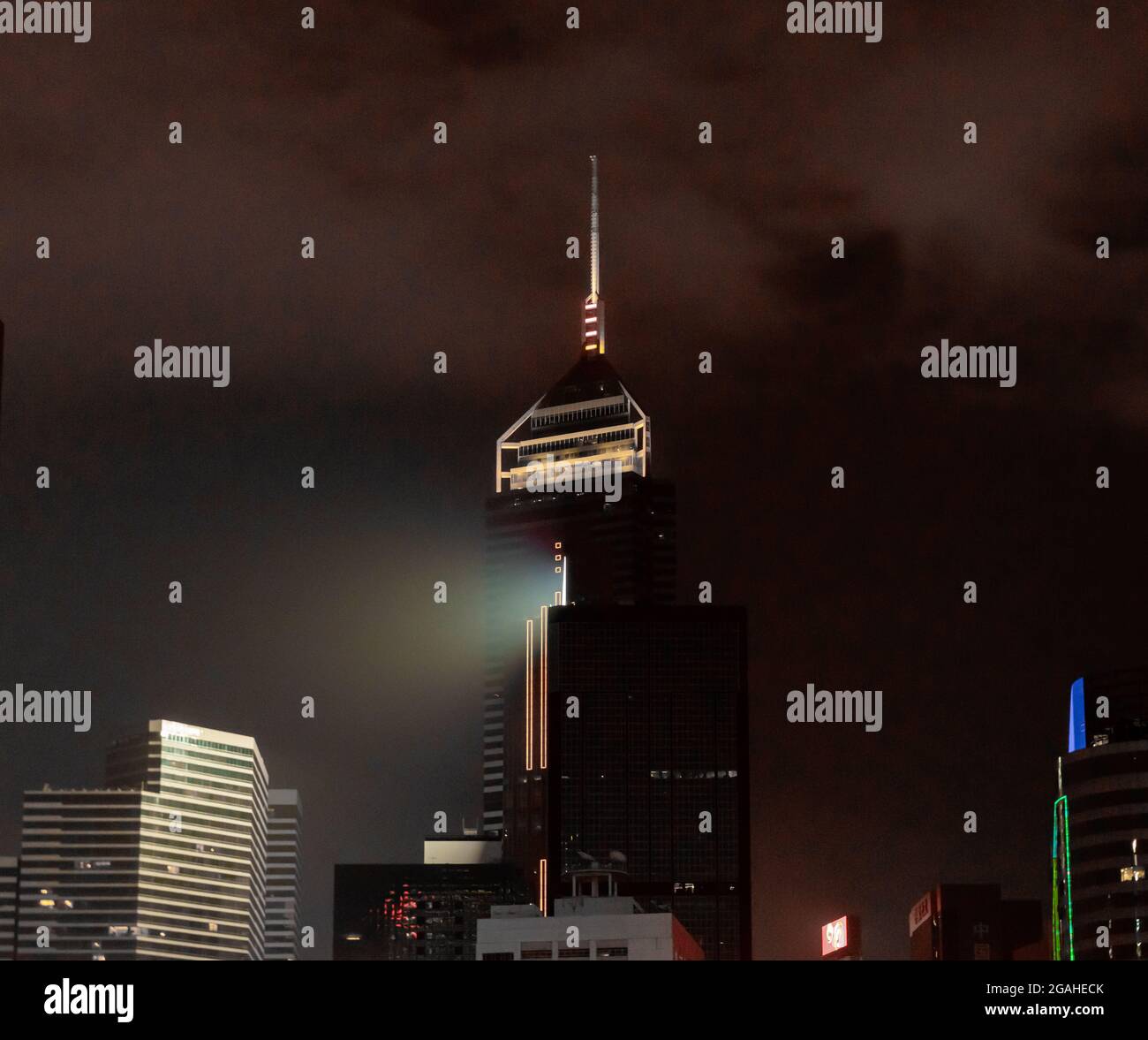Pyramidenförmiges Oberteil mit einer nadelförmigen Spitze des Wolkenkratzers Central Plaza, der den Spitznamen „Big Syringe“ trägt und nachts in Hongkong, China, beleuchtet wird Stockfoto