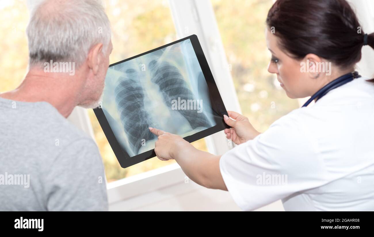 Ärztin zeigt dem Patienten einen Röntgenbericht an Stockfoto