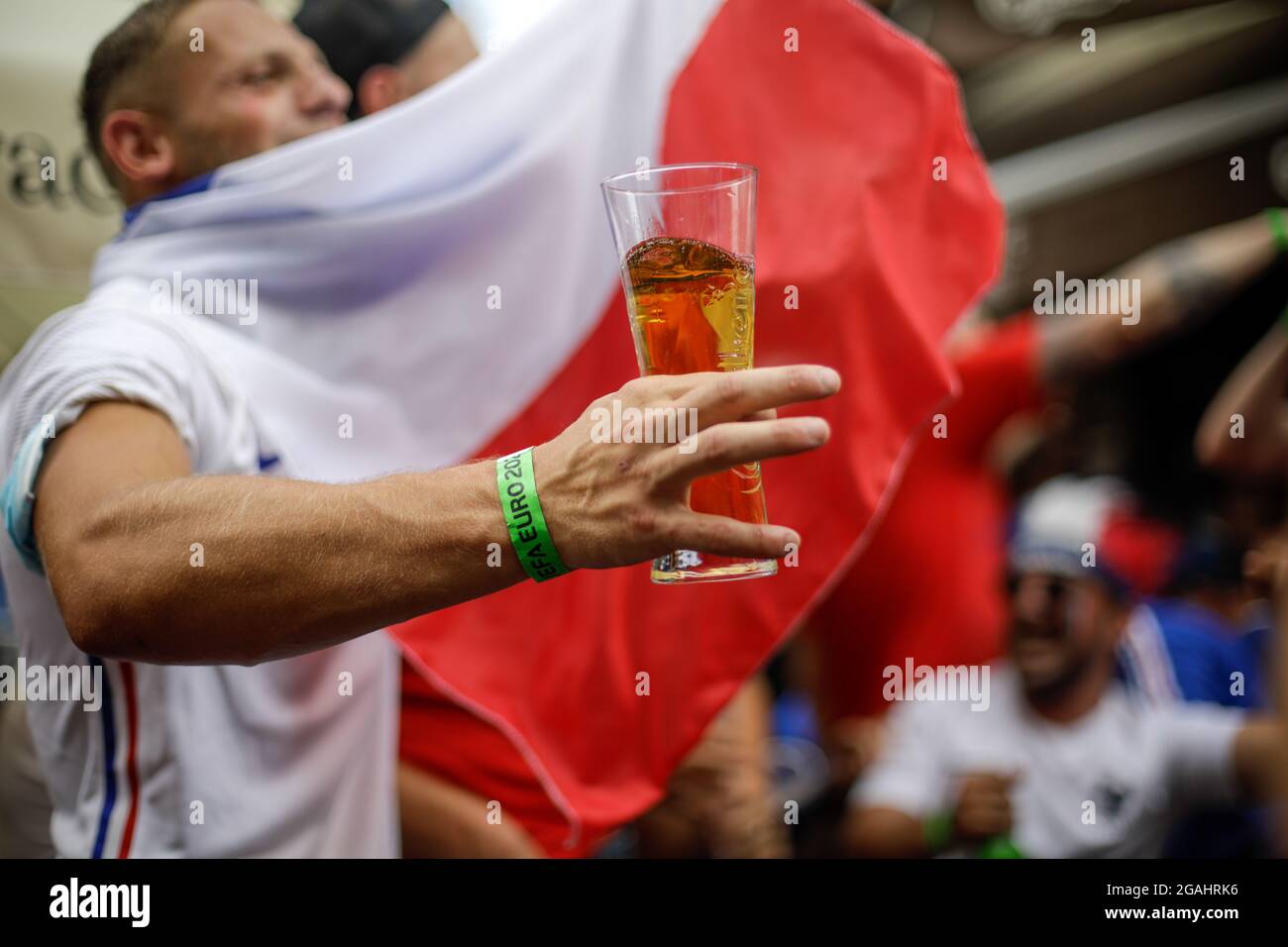 Bukarest, Rumänien - 23. Juli 2021:Bild mit geringer Schärfentiefe (selektiver Fokus) mit einem Euro 2020-Fan, der ein Bier hält und während eines Fußbeines feiert Stockfoto