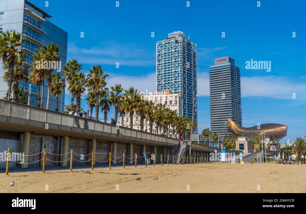 Barcelona, Spanien - 15. April 2021 - Panoramablick auf den Barceloneta-Strand (Platja Barceloneta) mit Wolkenkratzern und dem Mapfre-Hauptquartier im Hintergrund Stockfoto