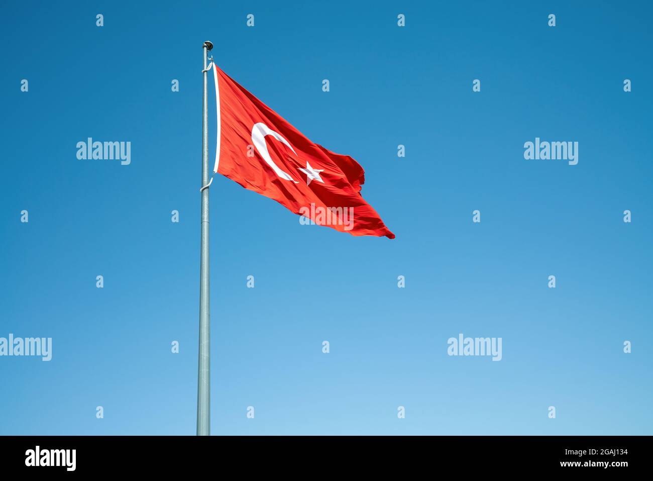 Plätschernde türkische Flagge auf windigem, blauem Himmel. Hochwertige Fotos Stockfoto