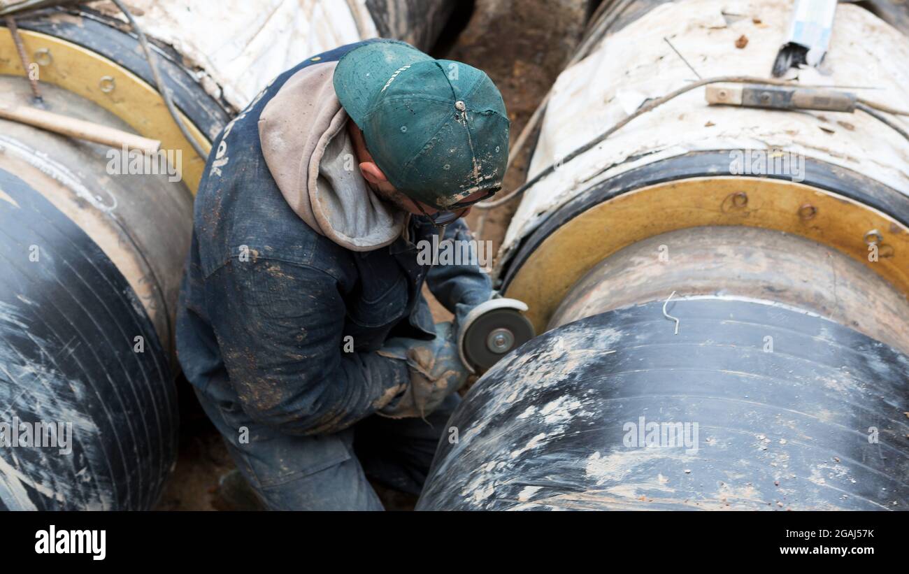 Odessa, Ukraine - 11. Oktober 2016: Reparatur des Heizkanals. Die Arbeiter, Schweißer, die durch Elektroschweißen und Gasschweißen an großen Eisenrohren bei einem Ableiter hergestellt wurden Stockfoto