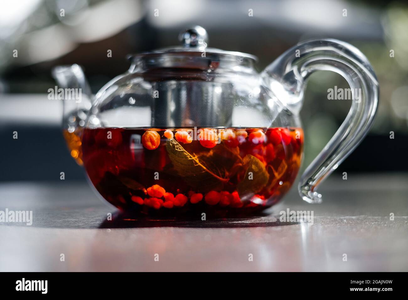 Glas-Teekannen mit heißem roten Beerentee, Nahaufnahme. Stockfoto