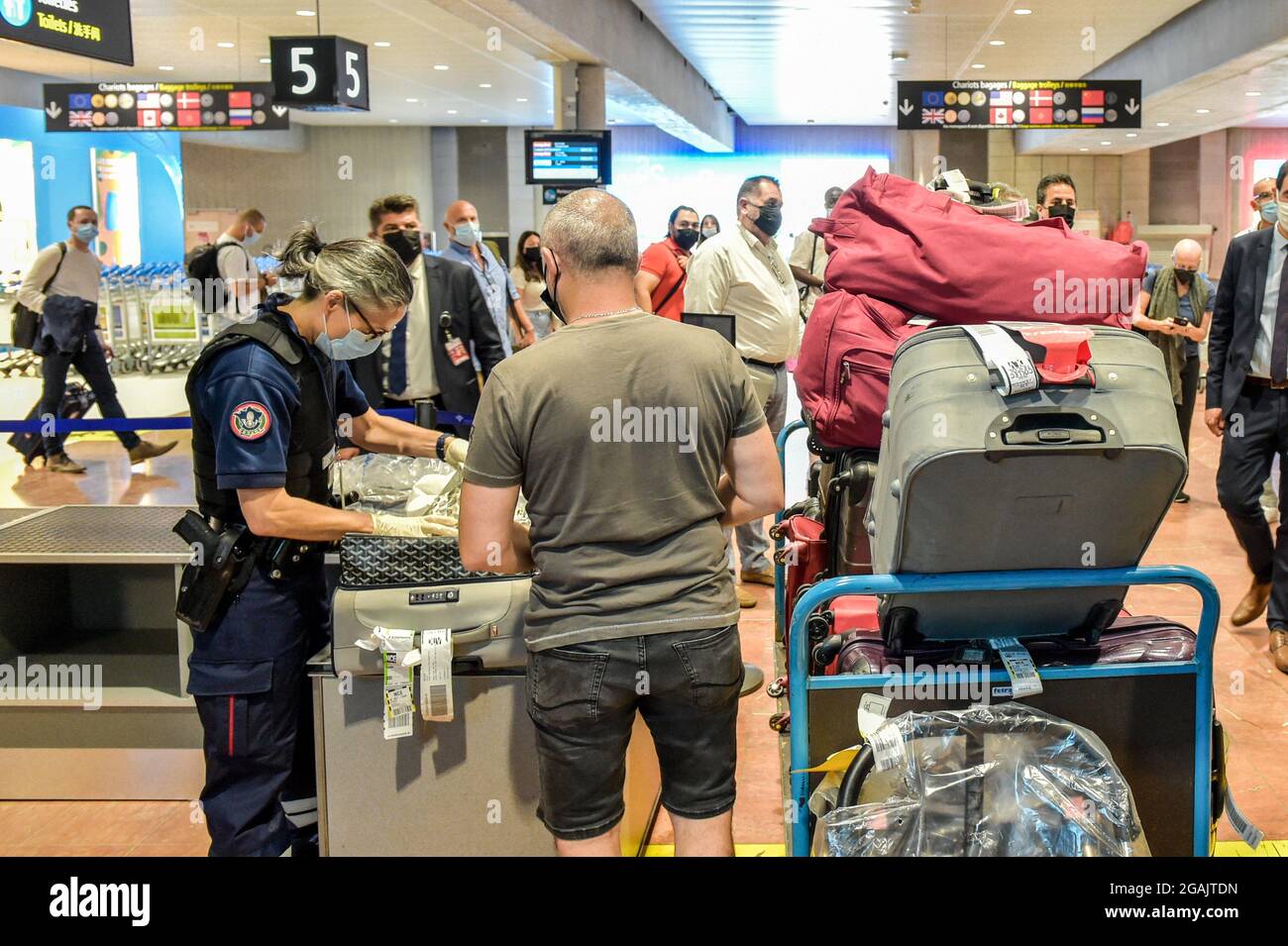 Ein Zollbeamter überprüft manuell das Gepäck von Passagieren, die von sogenannten „sensiblen“ Zielen am Flughafen Nizza – Cote d'Azur ankommen. Die nächste Verstärkung der Maßnahmen zur Bekämpfung der Coronavirus-Epidemie in Frankreich und die Installation des Sanitäranpasses bringt die Regierung dazu, die Kontrollen an den Grenzen zu verstärken. Zusätzlich zu den üblichen Kontrollen überprüfen die Zollbeamten und die Luft- und Grenzpolizei die Gültigkeit des Gesundheitspasses und der PCR-Tests, die Reisende bei ihrer Ankunft vorlegen. (Foto von Laurent Coust/SOPA Images/Sipa USA) Stockfoto