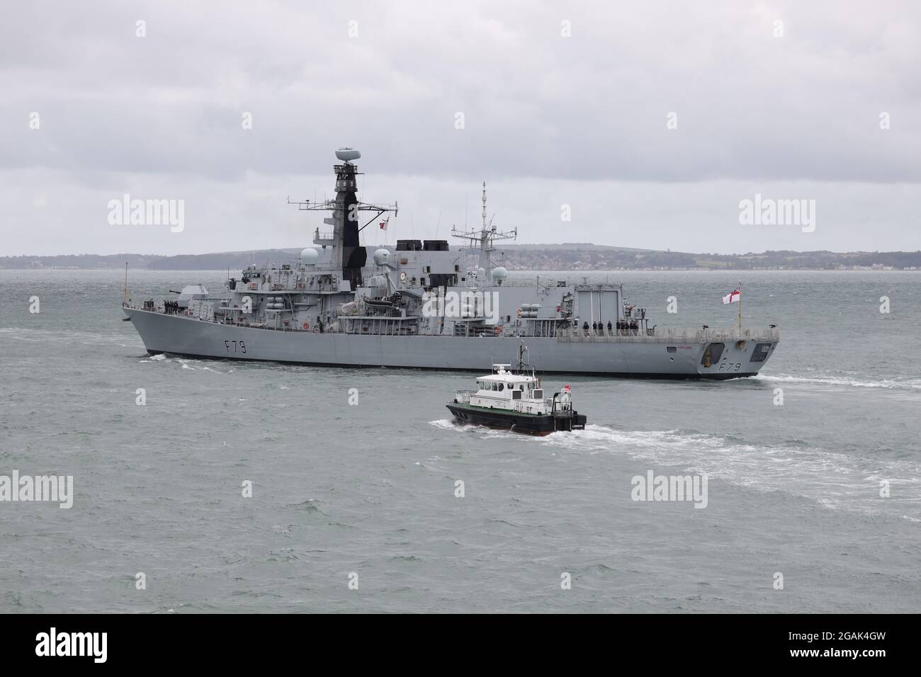 Die unter dem U-Boot-Schutz des Typs 23 der Royal Navy geführte Fregatte HMS PORTLAND führt in die Solent, begleitet vom Pilotstart des Admiralty-Piloten SOLENT SPIRIT Stockfoto