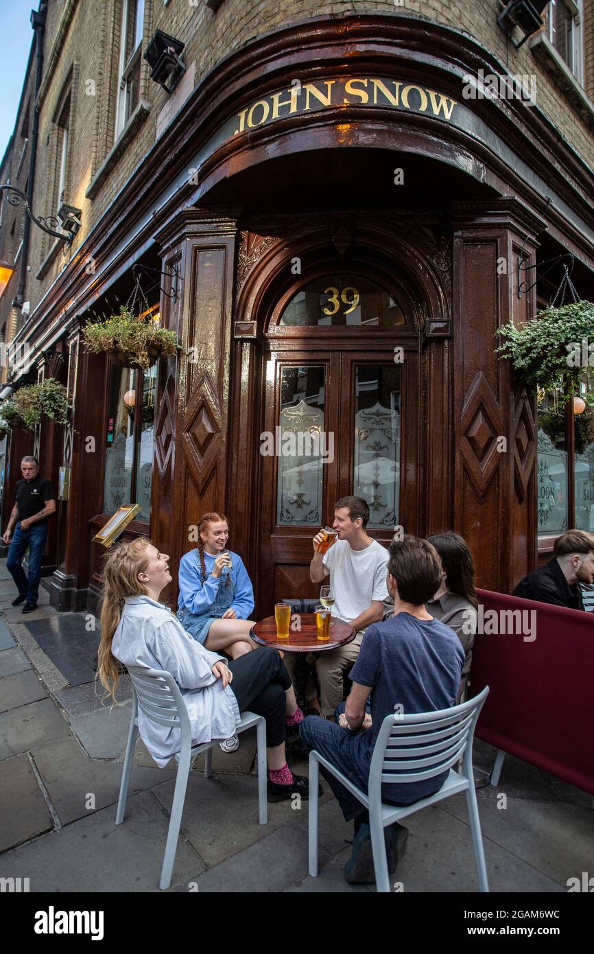 Menschen, die einen Drink vor dem John Snow Pub in der Broadwick Street, London, großbritannien, genießen Stockfoto