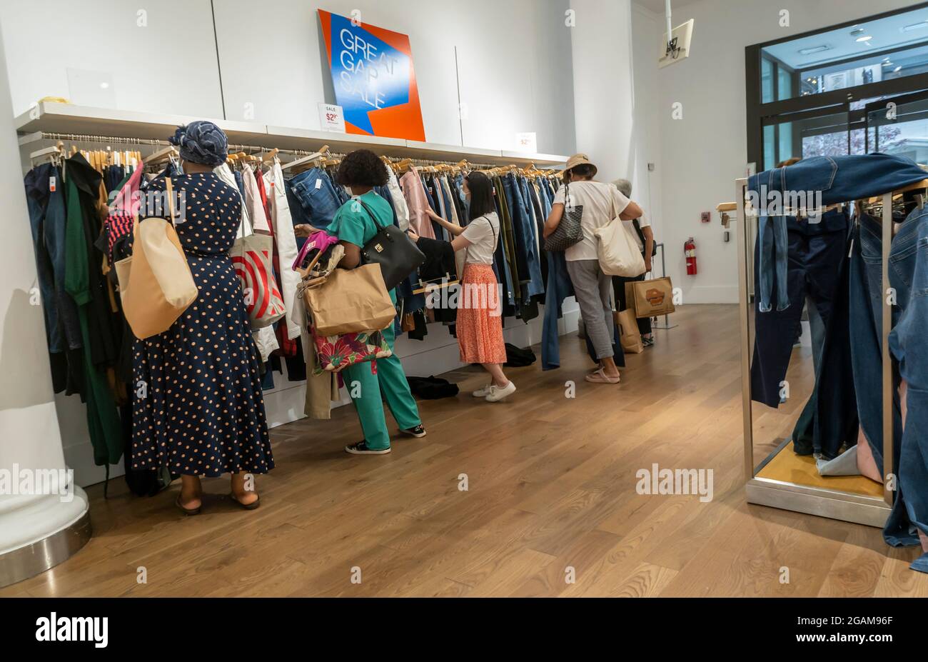 Am Samstag, den 24. Juli 2021, suchen Kunden nach Schnäppchen in dem sehr erschöpften Lagerbestand im bald schließenden Gap-Store auf der unteren Fifth Avenue in New York. In dem Blockladen gab es ein Gap Kids-, Gap Men- und Damenmode mit einem Athleta-Laden auf der anderen Straßenseite, der noch offen ist. (© Richard B. Levine) Stockfoto