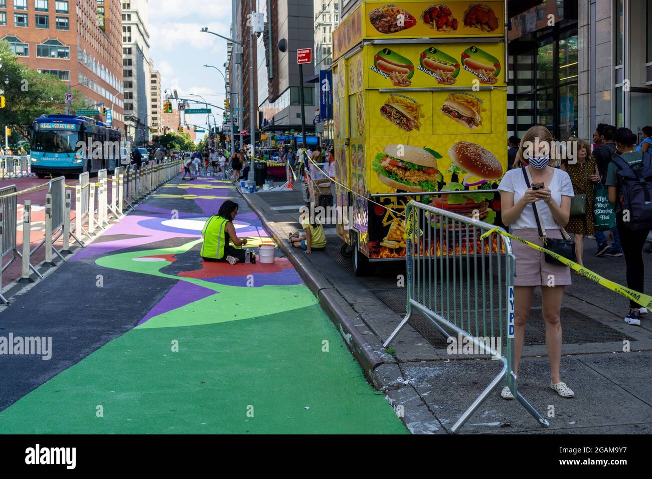 Gemeinsam mit den Künstlern GERALUZ und Werc beenden Freiwillige am Freitag, dem 30. Juli 2021, ihr zweiteiliges riesiges Wandgemälde mit dem Titel Collective Visions, das die 14th Street auf dem Union Square in New York schmückt. Die Wandmalereien besetzen Fußgängerzonen, die durch die Implementierung des 14. St Busway geschaffen wurden und von der NYC Dept. Of Transportation und der Union Square Partnership BID gehostet werden. (© Richard B. Levine) Stockfoto