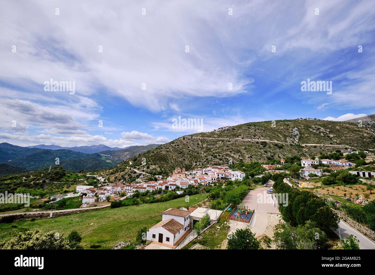 Blick auf weißes Dorf mit Bergen im Hintergrund, Alpandeire, Serrania de Ronda, Provinz Malaga, Andalusien, Spanien. Stockfoto