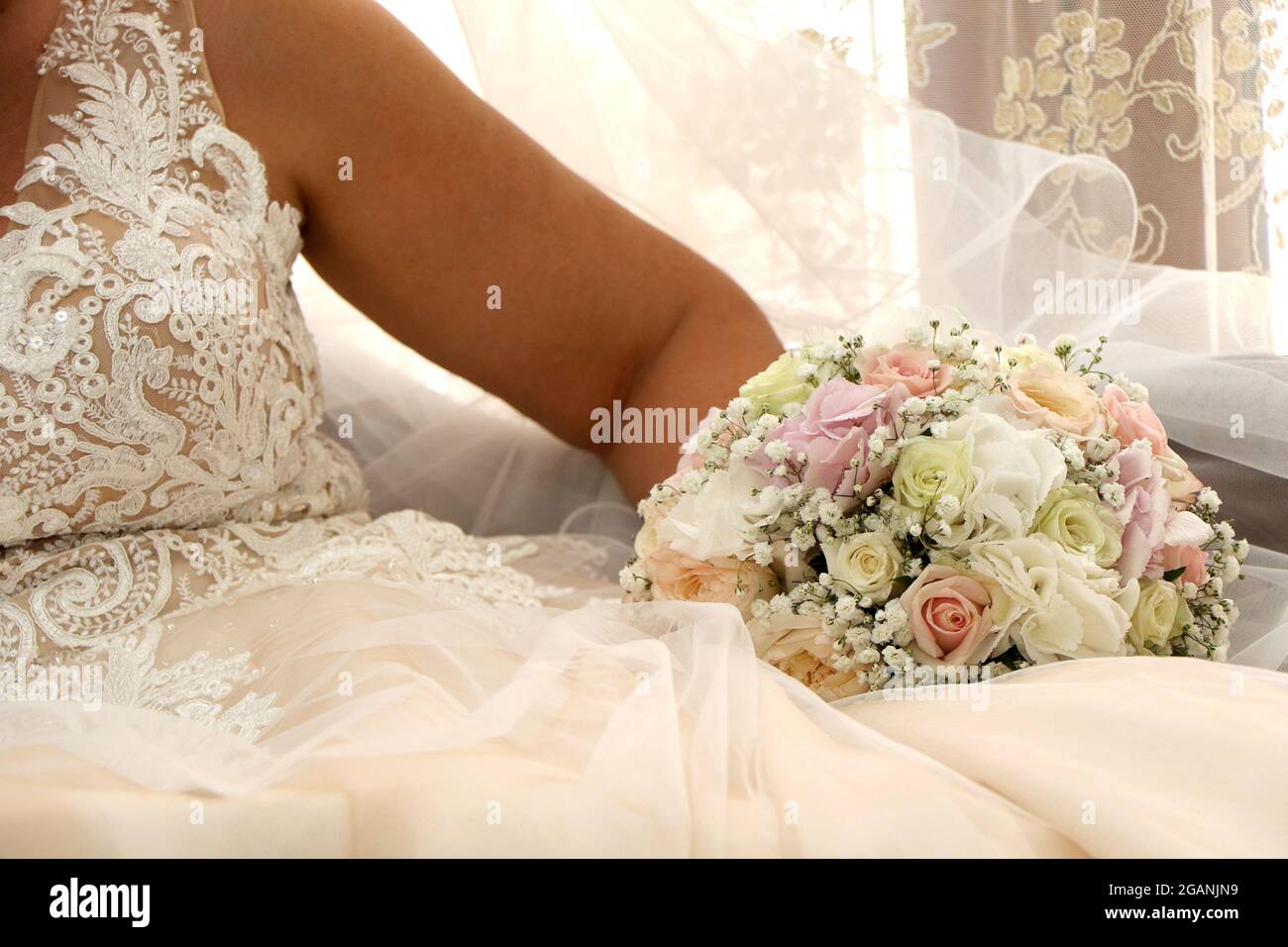 Braut in weißem Kleid mit dem Strauß in den Händen. Frau bereit für die Ehe Stockfoto