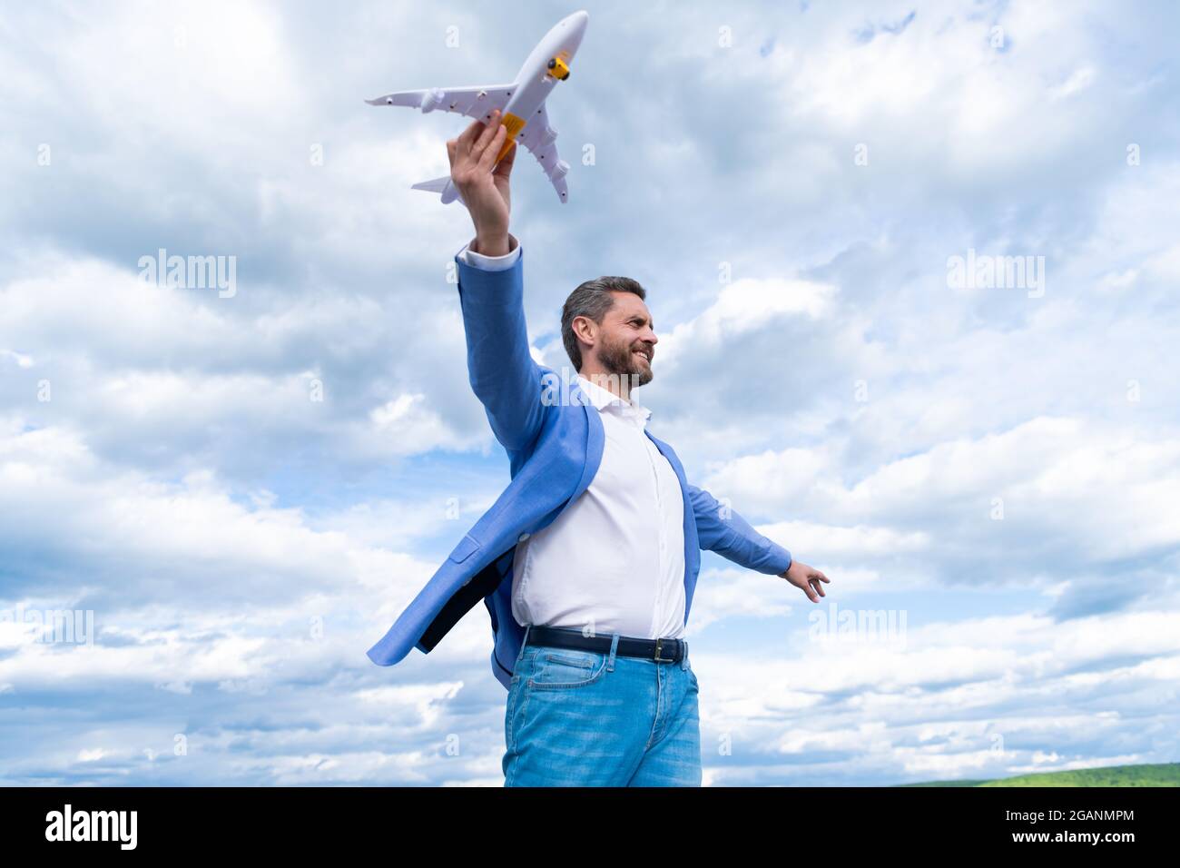 Erfolgreicher Mann im Anzug träumen. Unternehmer bereit für die Reise. Freiheit. Reifer Chef mit Flugzeug Stockfoto