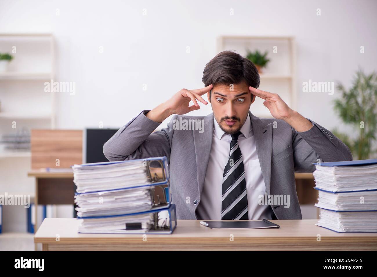 Junge Geschaftsmann Mitarbeiter Unglucklich Mit Ubermassiger Arbeit Im Buro Stockfotografie Alamy