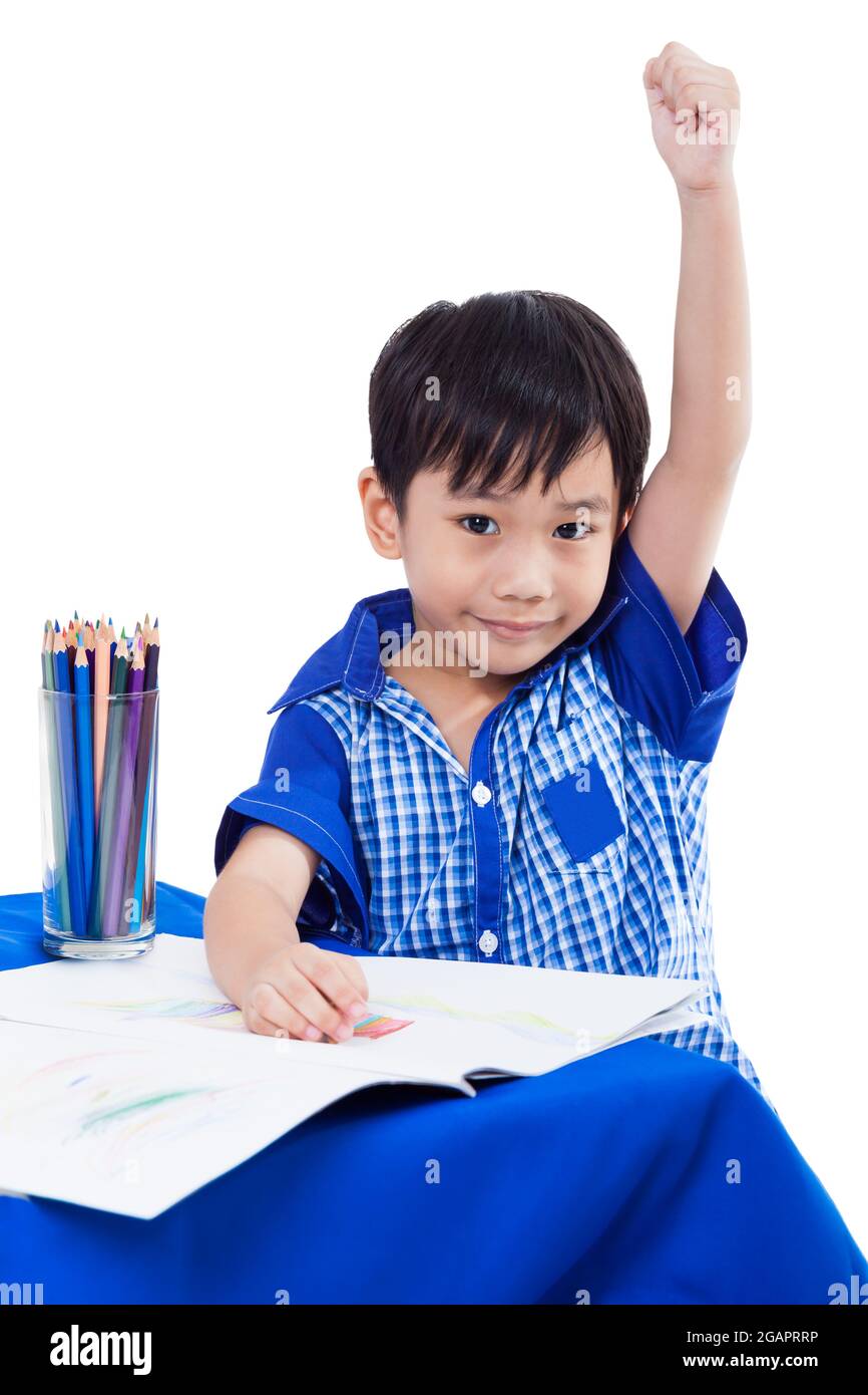 Happy Asian (thai) Junge lächelnd und heben die Hand mit Bildern Papier und Buntstifte, isoliert auf weißem Hintergrund, Bildungskonzept, für eine Broschüre le Stockfoto