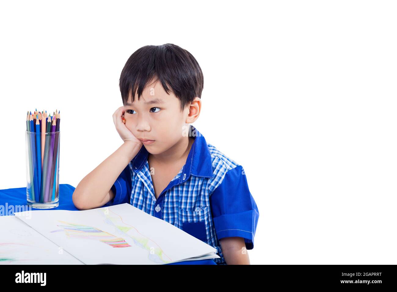 Kleiner asiatischer (thailändischer) Junge denkt und langweilige Emotion mit Bildern Papier und Farbstifte, isoliert auf weißem Hintergrund, Bildungskonzept Stockfoto