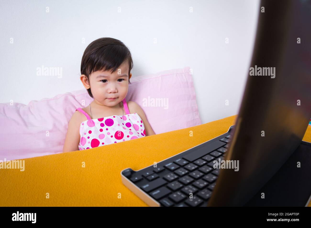 Ernsthaftes Kind, das auf einem digitalen Tablet-Computer sitzt und eine Geschichte sucht, Konzept über die Gesundheit und das Lernen optischer Augen, Studioaufnahme Stockfoto
