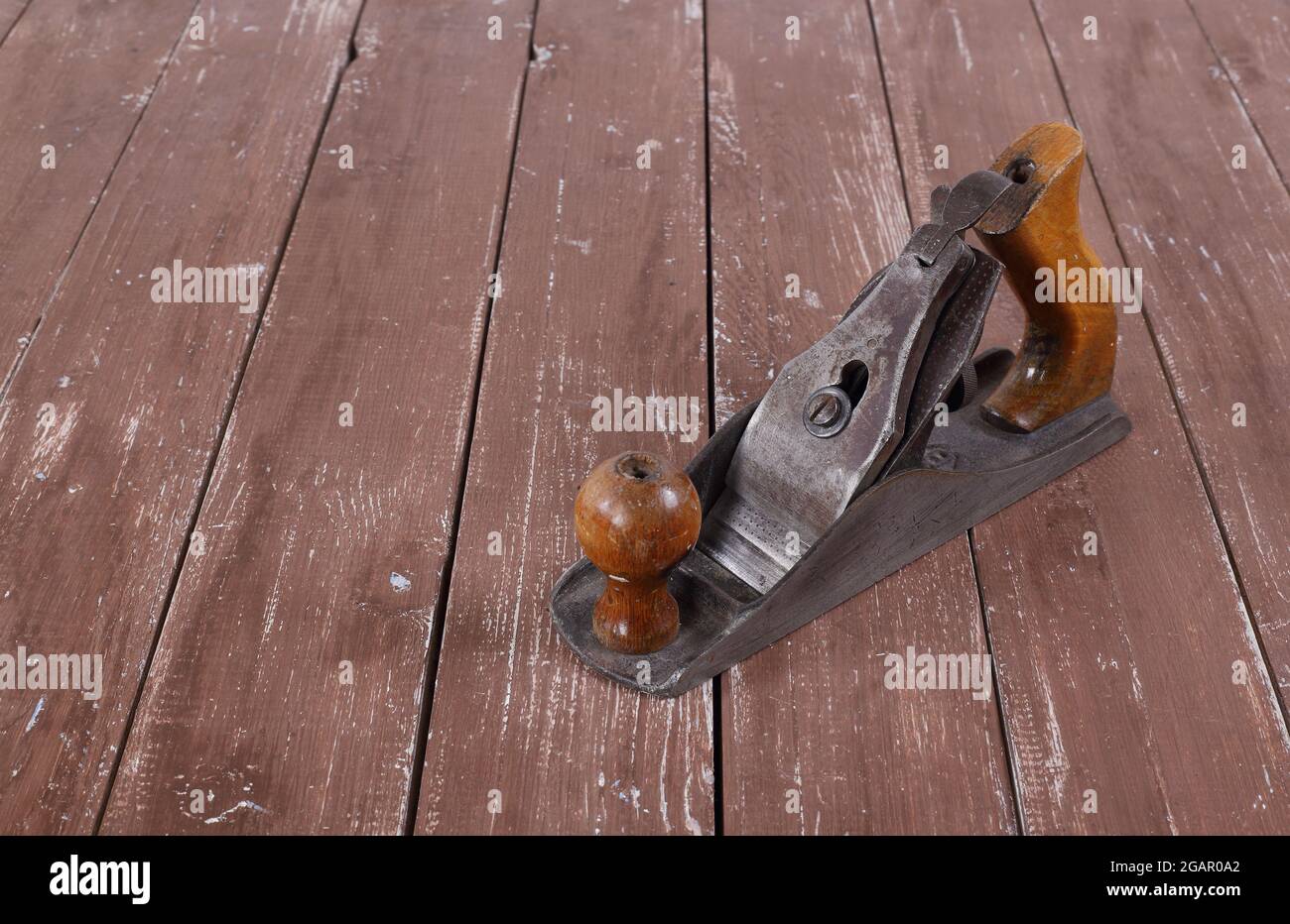 Werkzeuge Bau und Reparatur - Alte rostige Metall-Handflugzeug Nahaufnahme eines Holzhintergrunds. Stockfoto