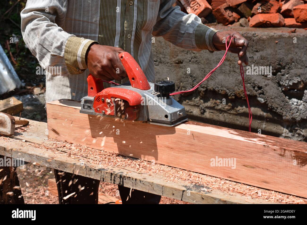 Elektrische Holzhobelmaschine, Mann bei der Arbeit mit Holz und Maschine. Stockfoto