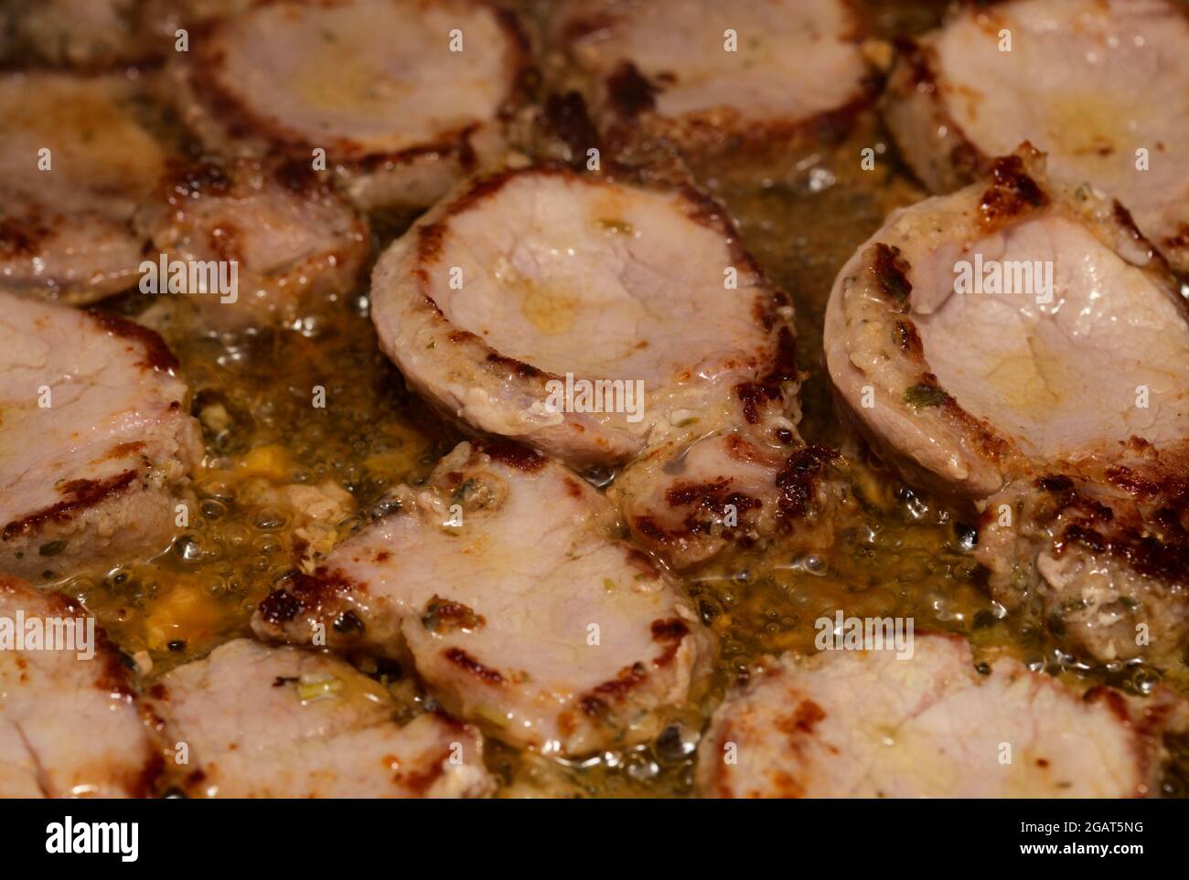 Mariniertes Schweinefleisch in reichlich Öl in einer Pfanne braten Stockfoto