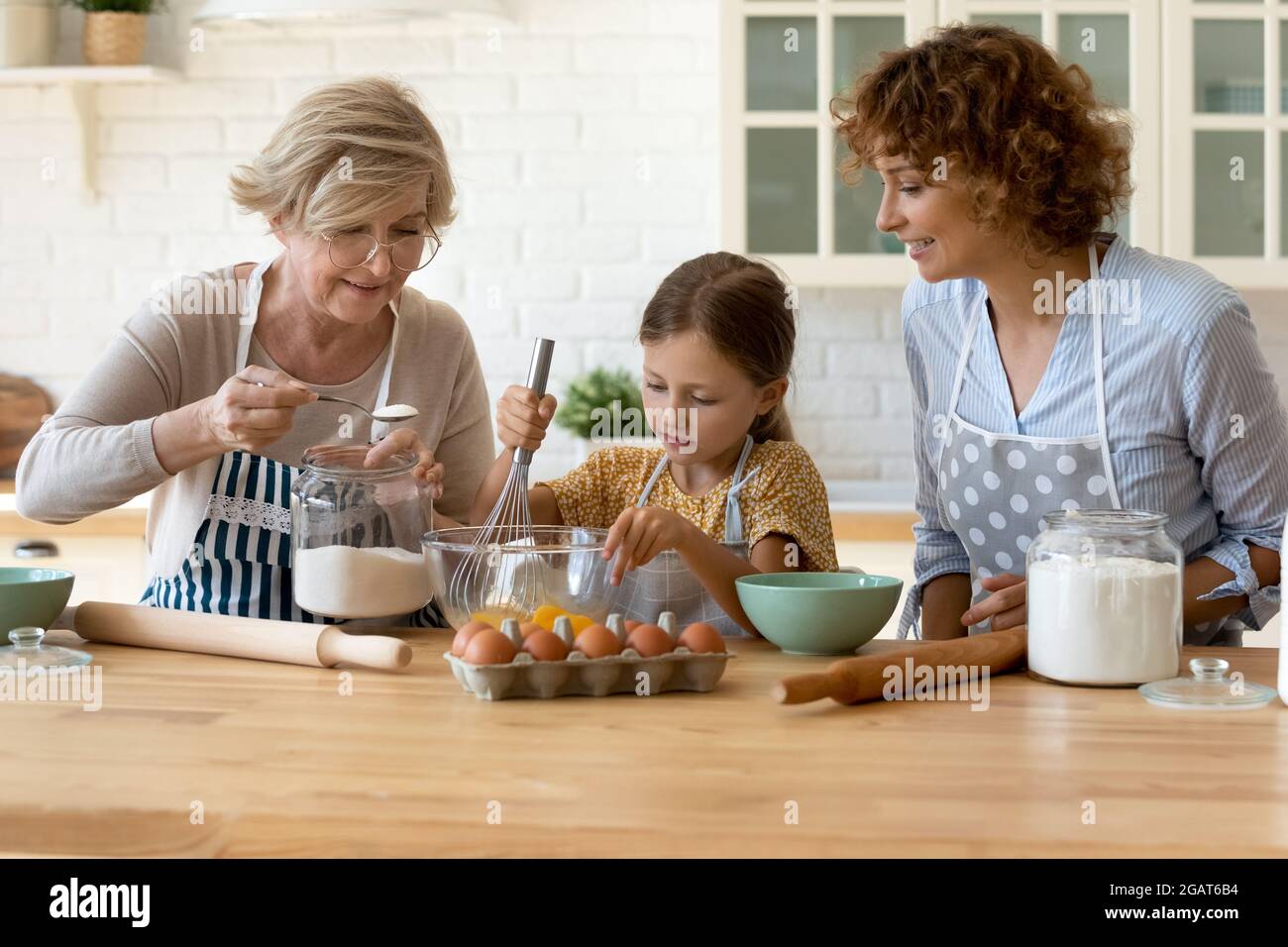 Glückliche drei Generationen von Frauen backen, kochen Teig zusammen Stockfoto