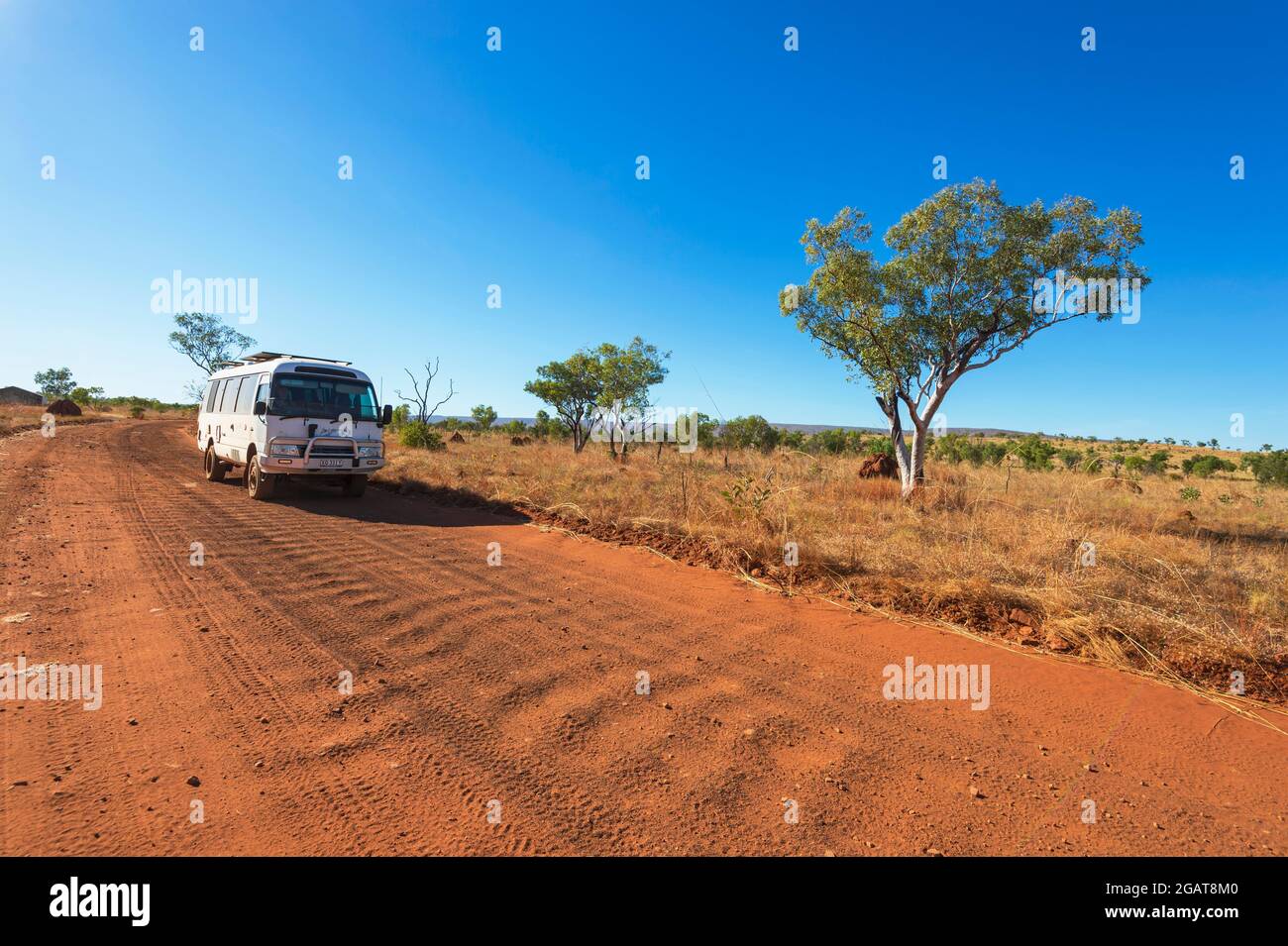 Ein Toyota Coaster Wohnmobil fährt auf einer Wellpappenstraße mit rotem Staub im Outback, Gibb River Road, Kimberley Region, Western Australia, WA, Australien Stockfoto