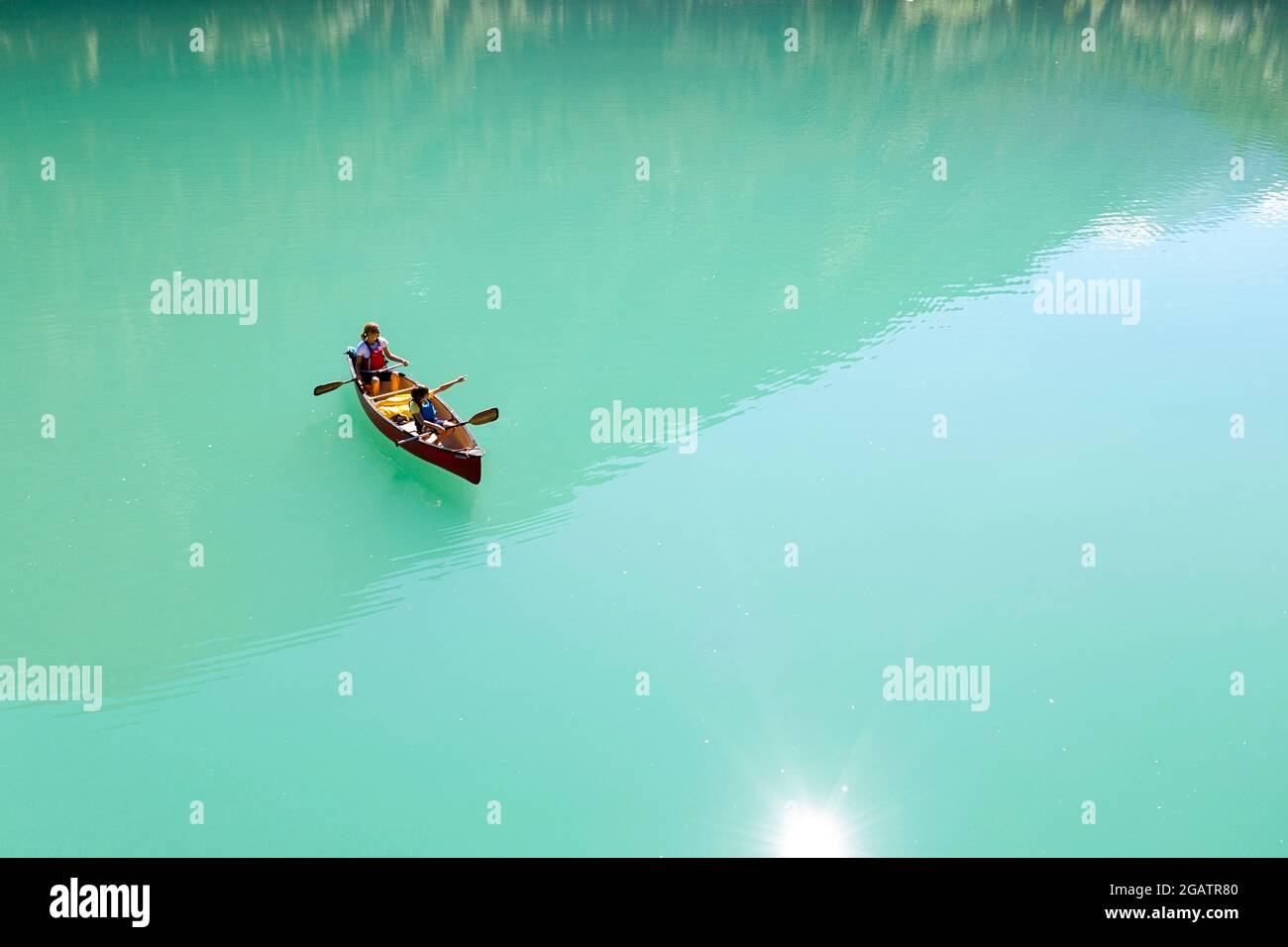 Mutter und Sohn im Kanu fahren auf Bergsee im Sommer alpine Landschaft mit Wasserfall im Hintergrund. Stillup Stausee, Stillup Lake, Österreich, Tirol Stockfoto