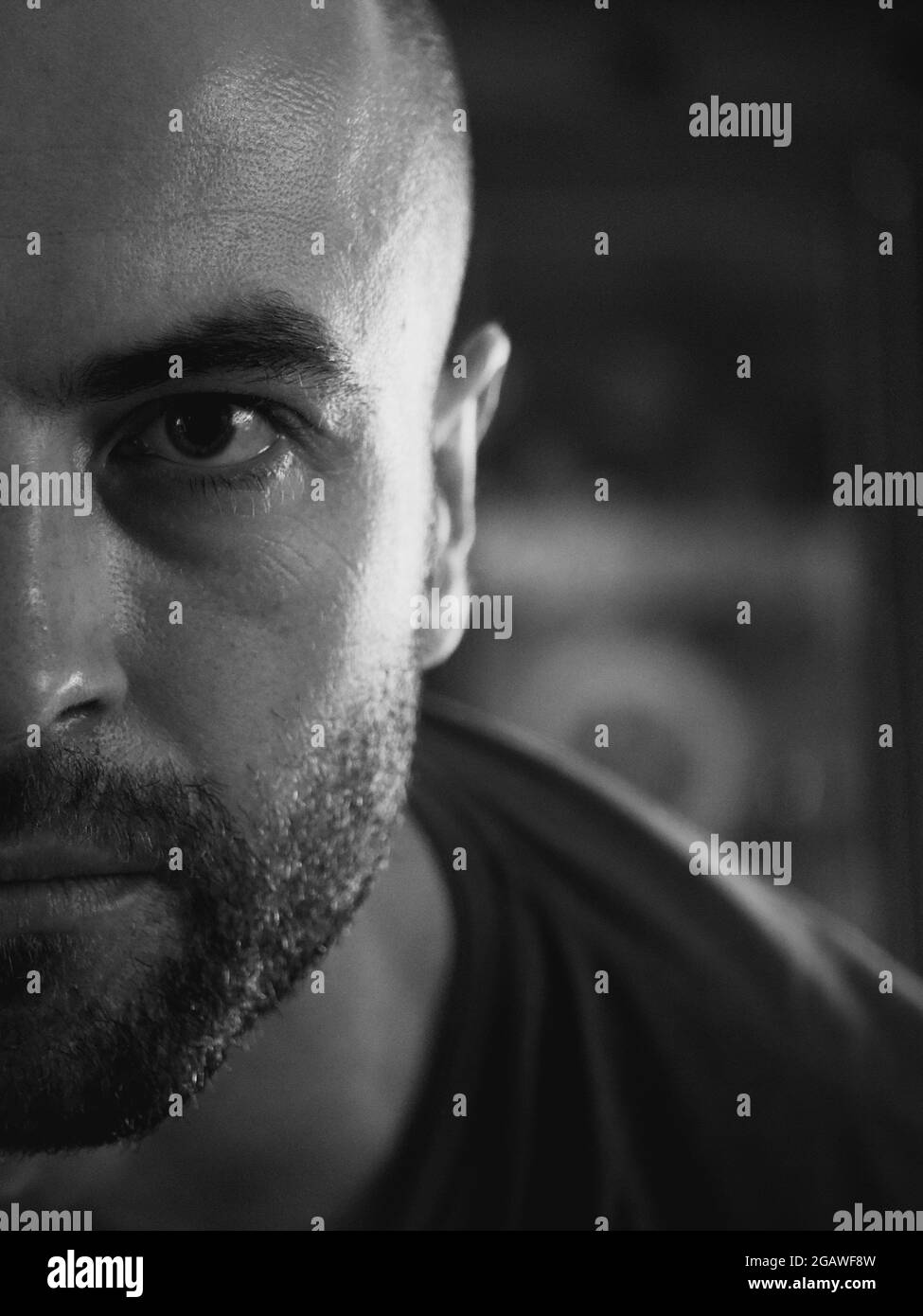 Der Blick eines weißen Mannes. Porträt, Nahaufnahme. Ein Mann mit einem Stoppeln im Gesicht. Schwarzweiß-Bild. Stockfoto