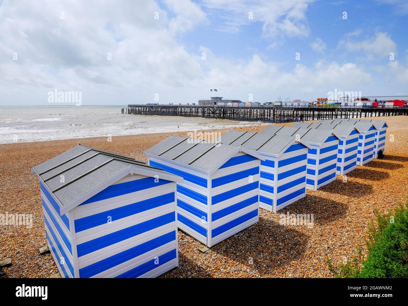 Hastings Pier und Strandhütten am Hastlings Beach, Hastling, East Sussex, Großbritannien Stockfoto