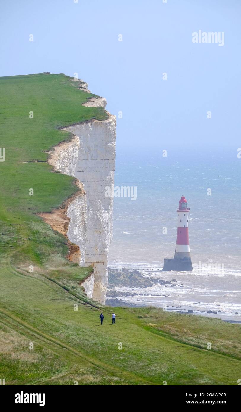 Spaziergänger auf dem South Downs Way, vorbei am Leuchtturm in Beachy Head, East Sussex, Großbritannien Stockfoto