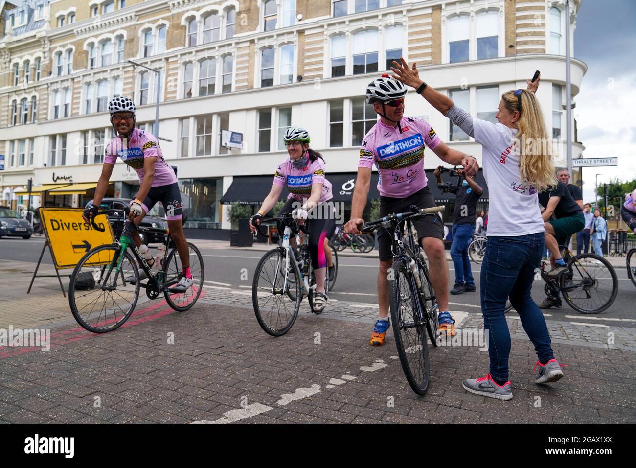 Die neu gewählte Abgeordnete von Batley & Spen, Kim Leadbeater (weißes T-Shirt), die Schwester des ermordeten Abgeordneten Jo Cox mit ihren Eltern Gordon und Jean Leadbeater, begrüßt die Jo Cox Way-Radfahrer, eine Gruppe von 70 Radfahrern mit gemischter Fahrfähigkeit, nach ihrer fünftägigen Reise von West Yorkshire auf dem Flat Iron Square in Southwark, London. Bilddatum: Sonntag, 1. August 2021. Stockfoto