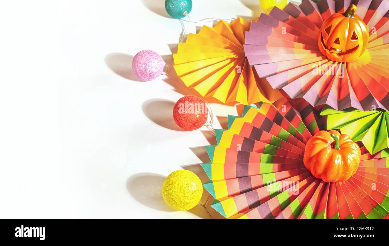 Kein Fokus, halloween, Gruß, horizontale Karte mit bunten Papierventilatoren, dekorativen Kürbis, Aufhellung und Jack o'Laterne auf weißem Hintergrund mit Stockfoto