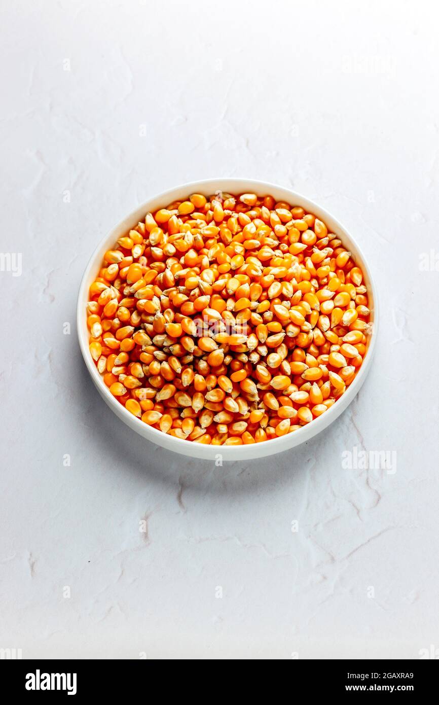 POPCORN – ungekocht auf weißem Hintergrund, isoliert – FOODPIX WEISS – COPYSPACE – RAUM FÜR TEXT Stockfoto