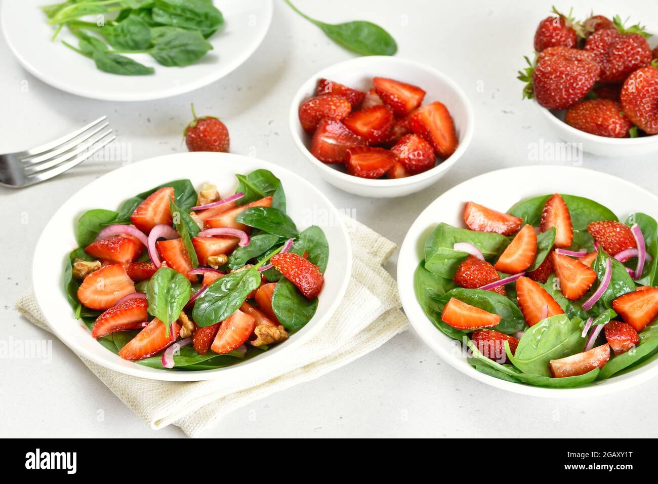 Gesundes Frühstück mit Obstsalat aus Erdbeere, Spinat und Walnuss in Schüssel Stockfoto