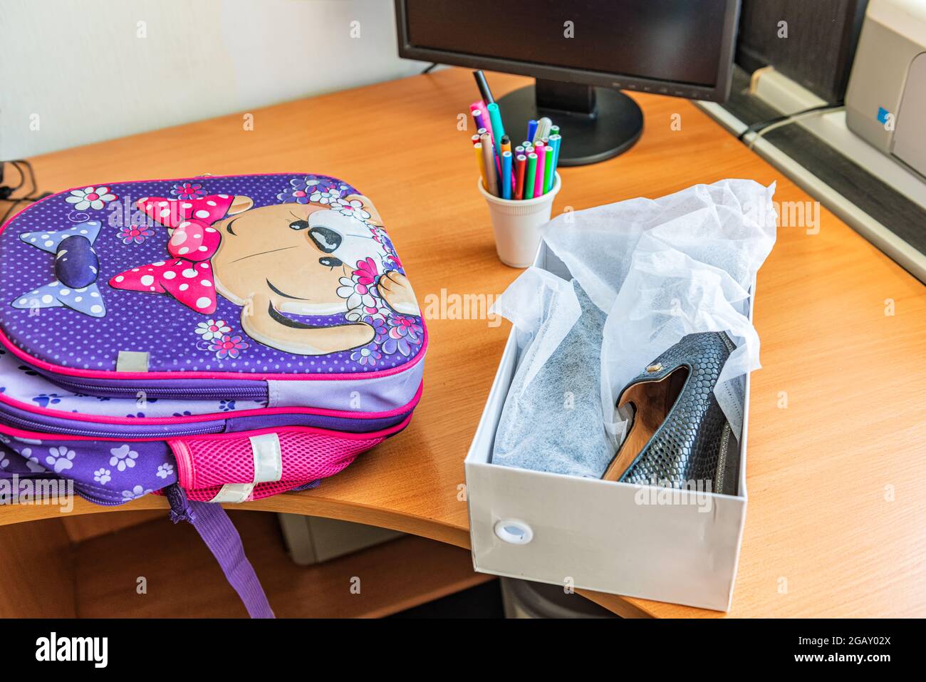Auf dem Computertisch befinden sich eine Schultasche und neue Schuhe Stockfoto