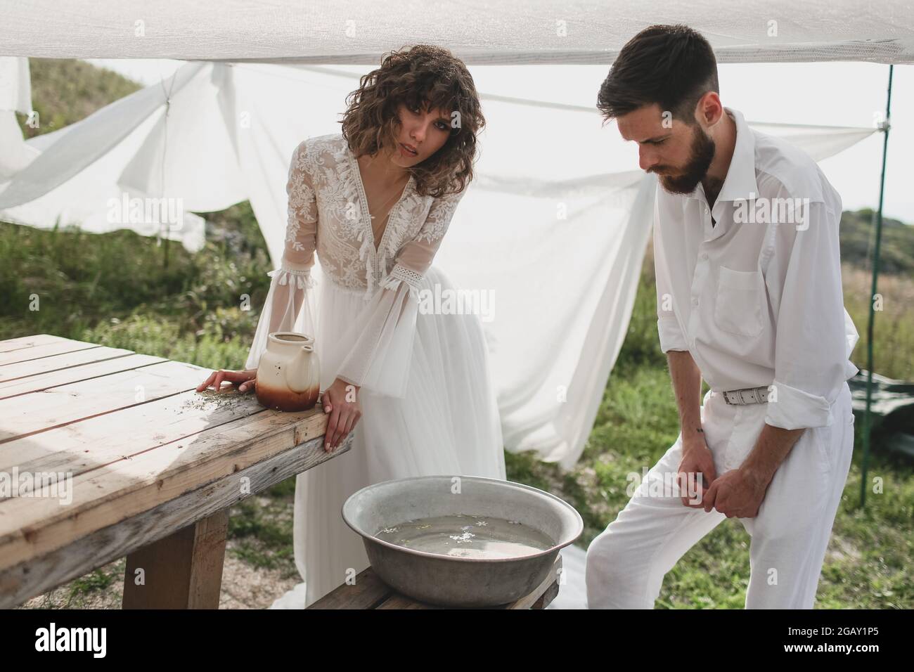 Braut und Bräutigam waschen sich unter dem Zelt. Öko Hochzeit in bogo und  Lifestyle Stockfotografie - Alamy
