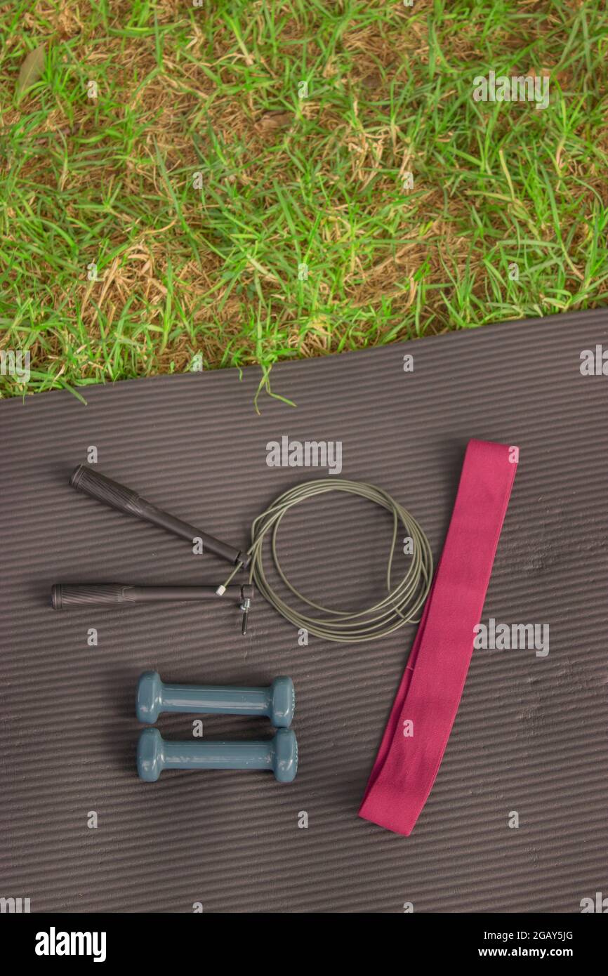 Vertikale Bild Sportgeräte (Gummiband, Gewichte und Seil) benötigt, um Training Klasse im Freien zu tun. Pilates Outdoor Workout 2021 Stockfoto