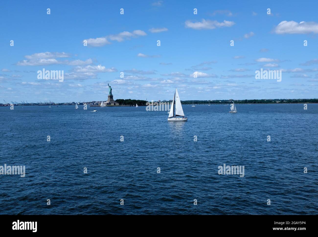 Die Freiheitsstatue im Hafen von New York, umgeben von Segelbooten Stockfoto