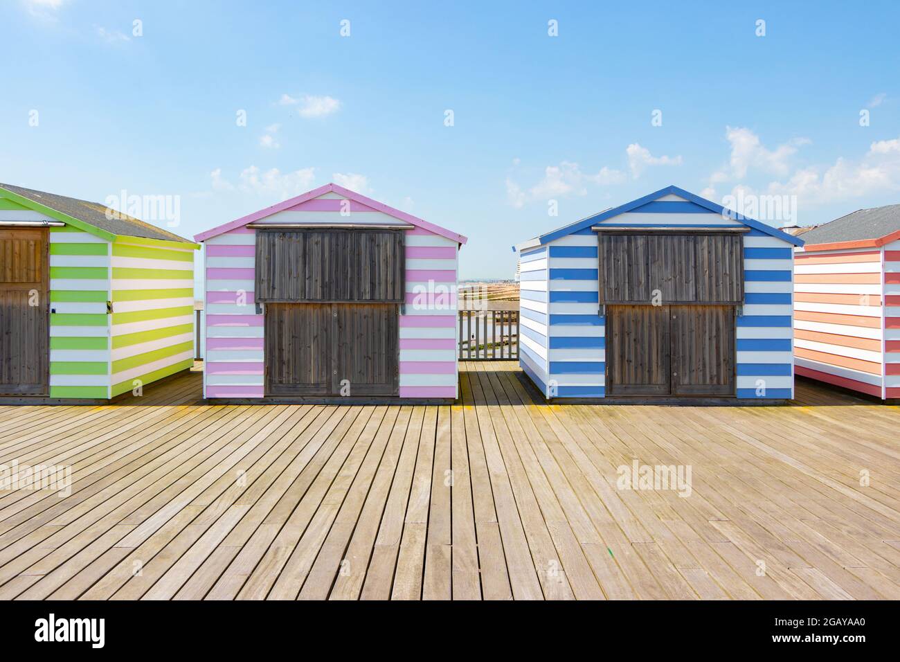 Strandhütten mit pastellfarbenen Bonbons am Pier in Hastings, East Sussex Stockfoto