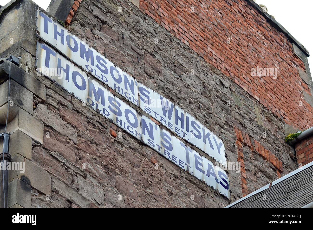 PERTH, SCHOTTLAND - 25. JUNI 2021: Alte Werbeschilder in der Old High Street für Thomson's Whisky and Tea, wahrscheinlich aus dem Ersten Weltkrieg Stockfoto