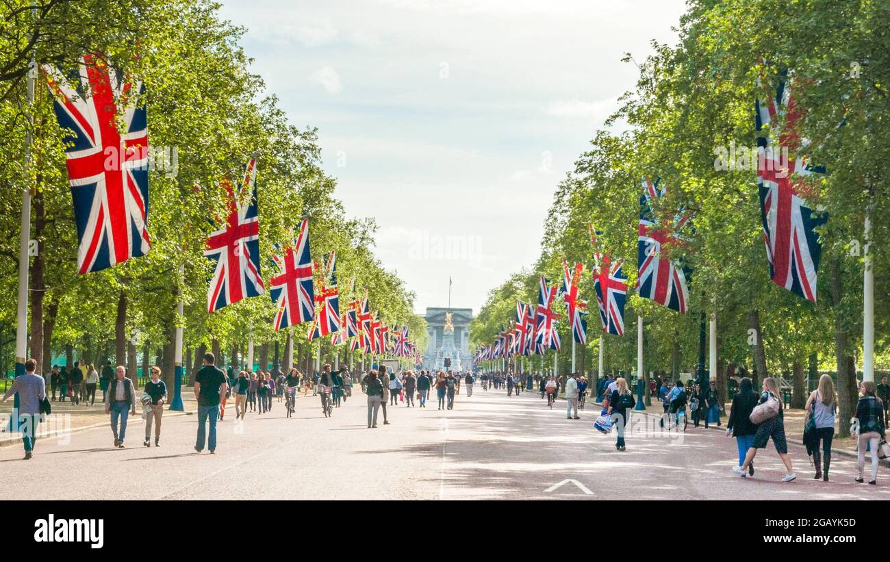 London - Vereinigtes Königreich, 2015-05-10. Londen feiert am VEday, dem Gedenken an den Tag des Sieges in Europa, den 70. Jahrestag des Endes des Zweiten Weltkriegs in Europa. Die Menschen schlendern die Mall entlang, eine von Bäumen gesäumte königliche Straße, die vom Trafalgar Square zum Buckingham Palace führt und auf beiden Seiten mit britischen Flaggen geschmückt ist. Hier mit Blick auf den Buckingham Palace. Foto archivieren. Stockfoto