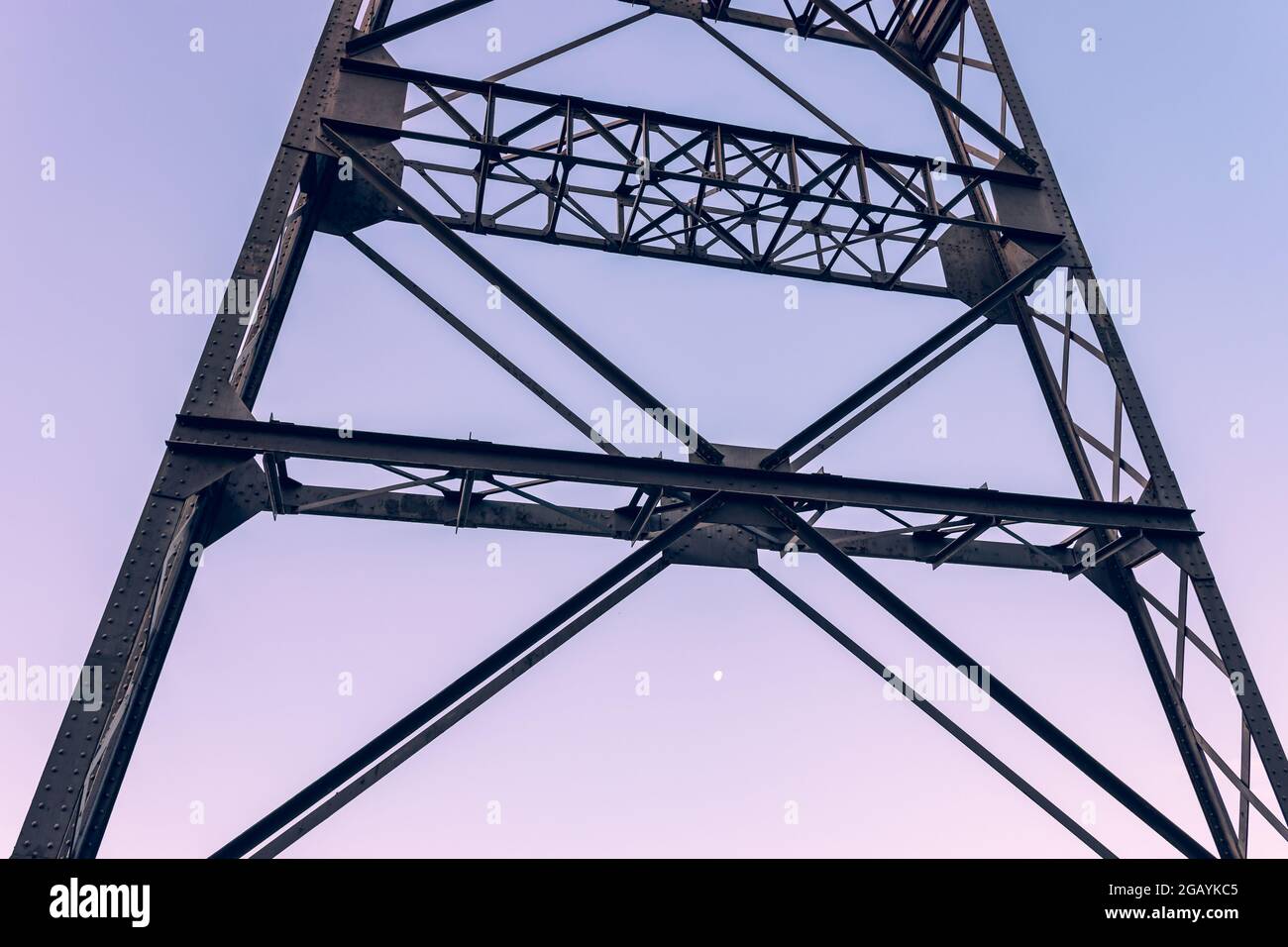Nahaufnahme einer Stahlkonstruktion eines Minenschachtturms gegen den Morgenhimmel und den Mond. Stockfoto